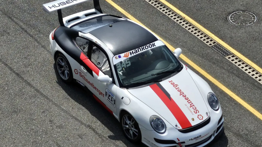 Weißes Rennauto mit roter Schneeberger Beschriftung auf einer Rennstrecke, aufgenommen aus erhöhter Perspektive.