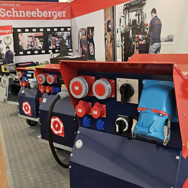 Schneeberger Messepräsentation mit mehreren Stromverteilern und Steckdosenfeldern in Rot-Blau.