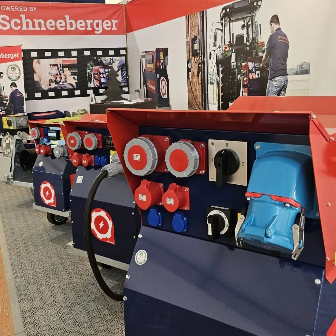 Schneeberger Messepräsentation mit mehreren Stromverteilern und Steckdosenfeldern in Rot-Blau.