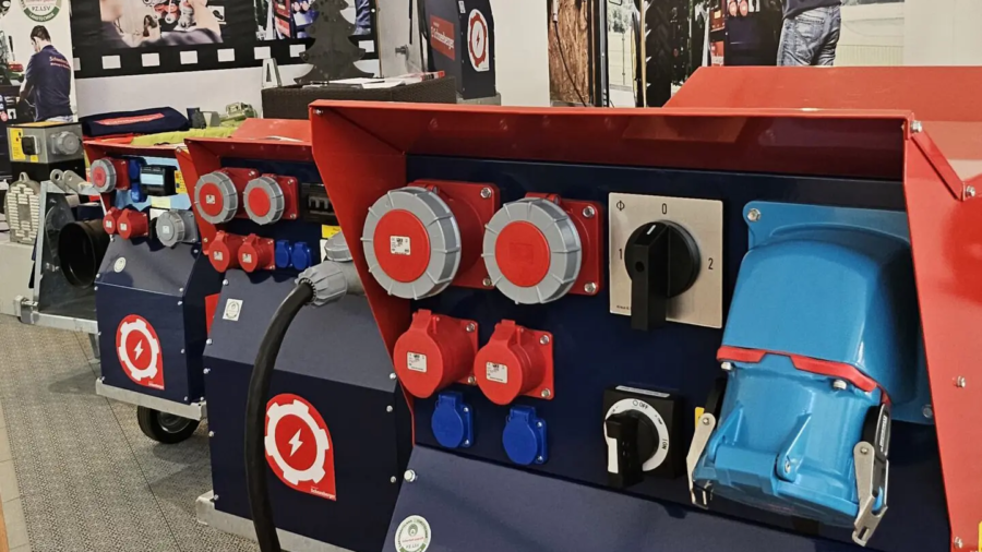 Schneeberger Messepräsentation mit mehreren Stromverteilern und Steckdosenfeldern in Rot-Blau.