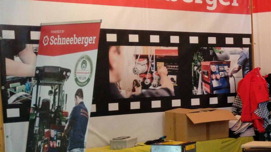 Messestand mit Schneeberger Branding und Banner im Hintergrund, aufgenommen im Innenbereich.