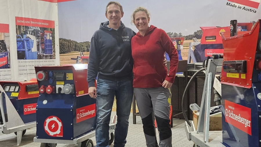 Zwei Personen stehen auf einem Messestand vor Schneeberger Geräten und Branding.