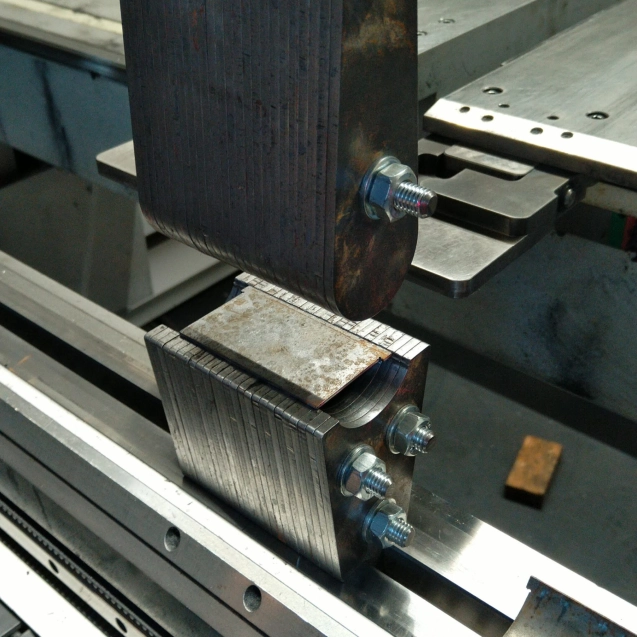 Nahaufnahme einer Metall-Sonderanfertigung mit verschraubten Bauteilen in einer Maschine.