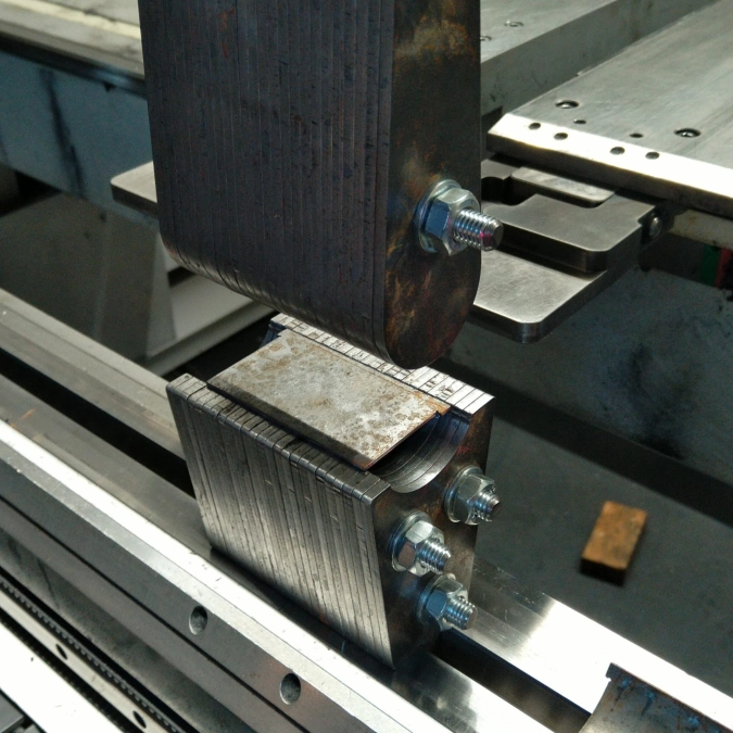 Nahaufnahme einer Metall-Sonderanfertigung mit verschraubten Bauteilen in einer Maschine.