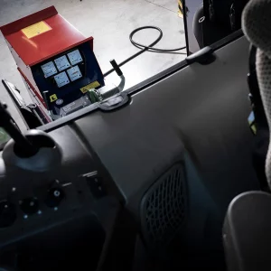 Sicht aus der Traktorkabine nach hinten auf einen laufenden Schneeberger Zapfwellengenerator in der Halle