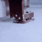 Fräskopf bearbeitet eine Metallplatte, Späne entstehen